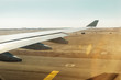 Aerial view out of airplane window while taking off from the runway of the airport with desert and blue sky