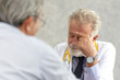 © thbangkok - Senior medical doctor or chief doctor giving a consultation to her male patient and explaining medical informations and diagnosis at the clinic or hospital.