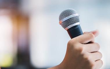 Semiar Conference Concept : hands holding businesspeople speech or speaking with microphones in seminar room, talking for lecture to audience university, Event light convention hall Background.