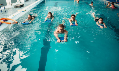 Wall Mural - Male trainer swims with female aqua aerobics group