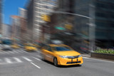 Fototapeta Miasta - New York City yellow taxi cab speeding through the streets of Manhattan with motion blur effect