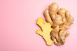Trendy food flat lay concept on light pink background with fresh big ginger root close up copy space isolated