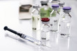 Vials of different size next to syringes at a hospital table, conceptual image