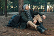 © Andrii - Pensive hipster guy wanderlust with touristic backpack enjoy tranquility during exploring nature environment,