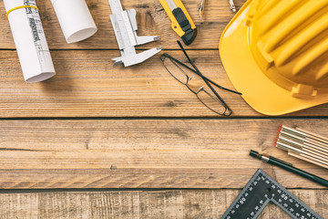 Architect workplace. Project construction blueprints and engineering tools on wooden desk, copy space