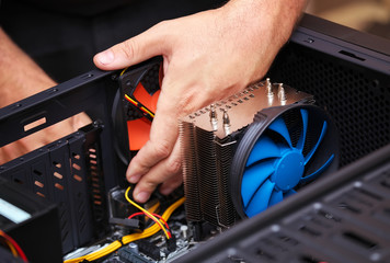 Computer technician installs cooling system of computer. Assembling PC