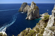 View of the Faraglioni rocks off the coast of Capri, with boats speeding towards them