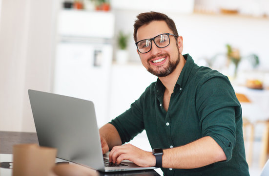 Happy man businessman, freelancer, student working at computer at home .