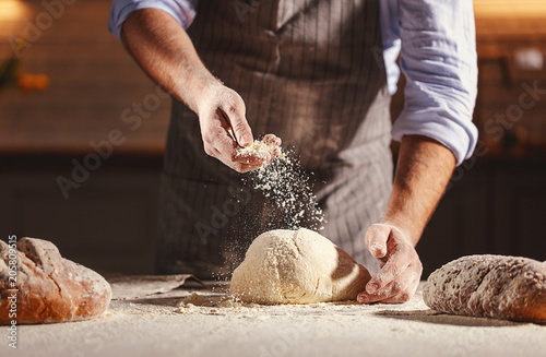 Fotomural Hands of baker kneading dough