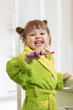 Smiling child kid girl brushing teeth in bathroom