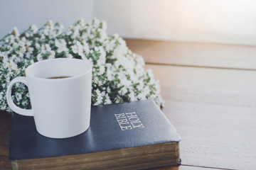 Wall Mural - a cup of coffee and holy bible with flowers on wooden bible with copy space