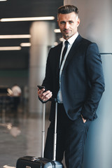 Canvas Print - Smiling mature businessman holding mobile phone