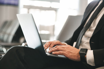 Wall Mural - Close up of businessman dressed in suit using laptop