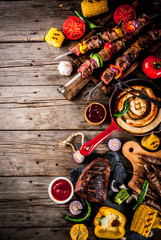 Assortment various barbecue food grill meat, bbq party fest - shish kebab, sausages, grilled meat fillet, fresh vegetables, sauces, spices, on old wooden rustic table, above copy space