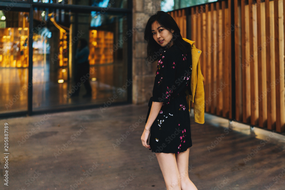 Young asian woman wearing mini dress looking back at the camera on her way to the Young asian woman wearing mini dress looking back at the camera on her way to the