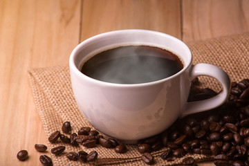 Black coffee,Coffee Cup and Beans on Wooden Table