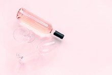 Bottle Of Pink Wine And Two Glasses Of Wine On A Soft Light Pink Wood Table, Mock Up. Flat Lay, Top View, Copy Space 
