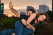 Young couple outdoor portrait having fun in a downtown urban park