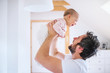 © Halfpoint - Father with a toddler girl in bedroom at home, having fun.