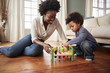© Monkey Business - Mother And Young Son Playing With Wooden Toy At Home