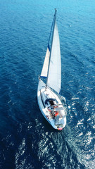 Aerial birds eye view from drone of yacht in deep blue sea