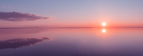 Landscape beautiful golden sunset red sky solt lake saline Elton Baskunchak. The sun sets behind the horizon