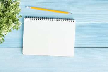Wall Mural - blank notebook with and pencil on blue background,flat lay photo of notebook for your message