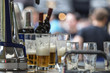 © igorgeiger - Glass glasses with beer and a bottle of wine on the bar at an open festival.