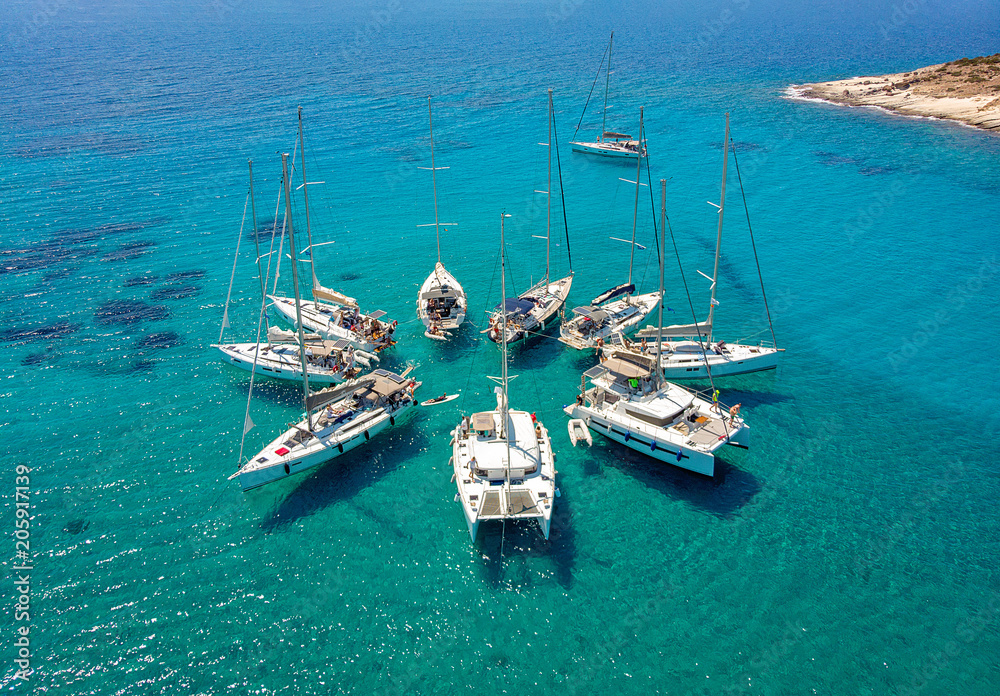 Sailing boats in a star formation in turquoise tropical bay. View from above. - obrazy, fototapety, plakaty 