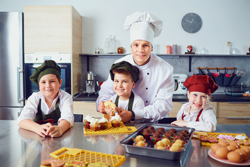 Wall Mural - Children learn to cook in the classroom in the kitchen.