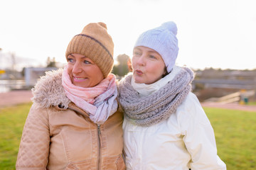 Two mature beautiful women together against scenic view of natur