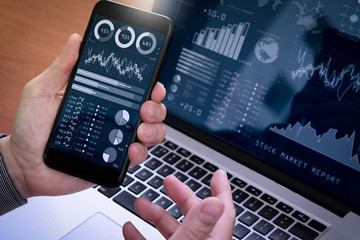 Aufkleber - Investor analyzing stock market report and financial dashboard with business intelligence (BI), with key performance indicators (KPI).Businessman using smart phone with laptop computer.