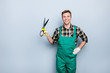 People lifestyle hobby person concept. Portrait of friendly glad professional toothy smile expert gardener holding showing garden scissors in hands wearing classic outfit isolated on gray background