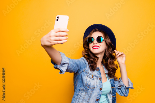 Fotomural Portrait of cool cheerful girl having video-call with lover holding smart phone