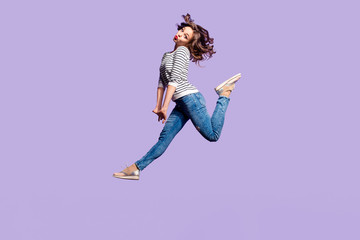 Wall Mural - Portrait of lovely foolish girlfriend jumping in the air blowing sending kiss with pout lips having red lipstick pomade isolated on violet background, crazy people lifestyle concept