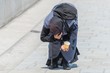 Alte gebückt gehende Bettlerin in einer Fußgängerzone, Deutschland