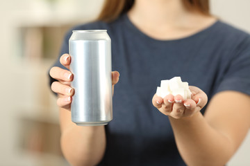 Wall Mural - Woman hands holding a soda drink can and sugar cubes