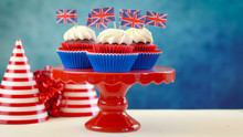 Red White And Blue Theme Cupcakes And Cake Stand With UK Union Jack Flags For Queen's Birthday Weekend Celebration Or Great Britain Party Food.