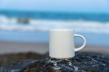 White Coffee Cup On The Rock At Sea.