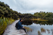 © Klanarong Chitmung - A young Asian man sitting on the path beside a beautiful lake in a cloudy day.