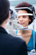 © Kzenon - Optician measuring women eyes with refractometer in optician shop