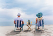 © Mediteraneo - Couple on a deck chair relaxing on the beach. Happy couple enjoy on the beach during summer vacations