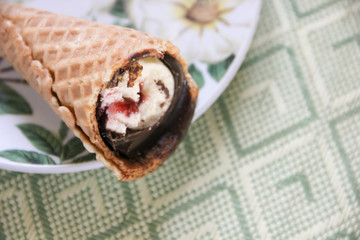 Wall Mural - Ice cream stuffed with chocolate icing in a waffle cone on a plate