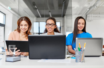 Canvas Print - business, teamwork and people concept - female team or businesswomen with tablet pc and laptop computers working at office