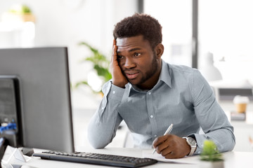 Wall Mural - business, people, paperwork and technology concept - stressed african american businessman with computer and papers working at office