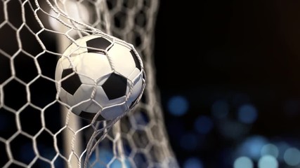 Soccer ball flies into the net on a stadium with yellow lights. In slow motion