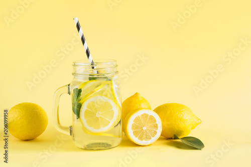 Fotografía Fresh summer fruits water or lemonade with lemon and mint on yellow background