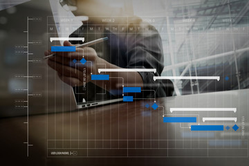 Wall Mural - business moment with laptop computer and graph business diagram and man working in the background