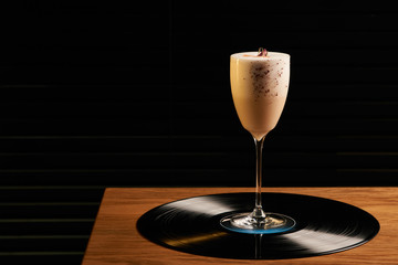 Wall Mural - Classical Lucy cocktail on vinyl tray background. Cocktail with Gin, Yogurt, liqueur, Lychee puree, Cardamom syrup, egg white, Lemon juice. Sweet cocktail with spicy taste, close-up