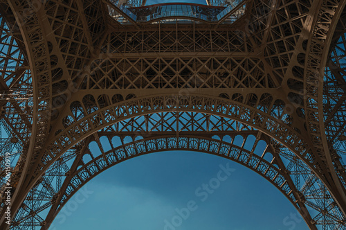 Cuadros en Lienzo Bottom view of Eiffel Tower made in iron and Art Nouveau style, with sunny blue sky in Paris